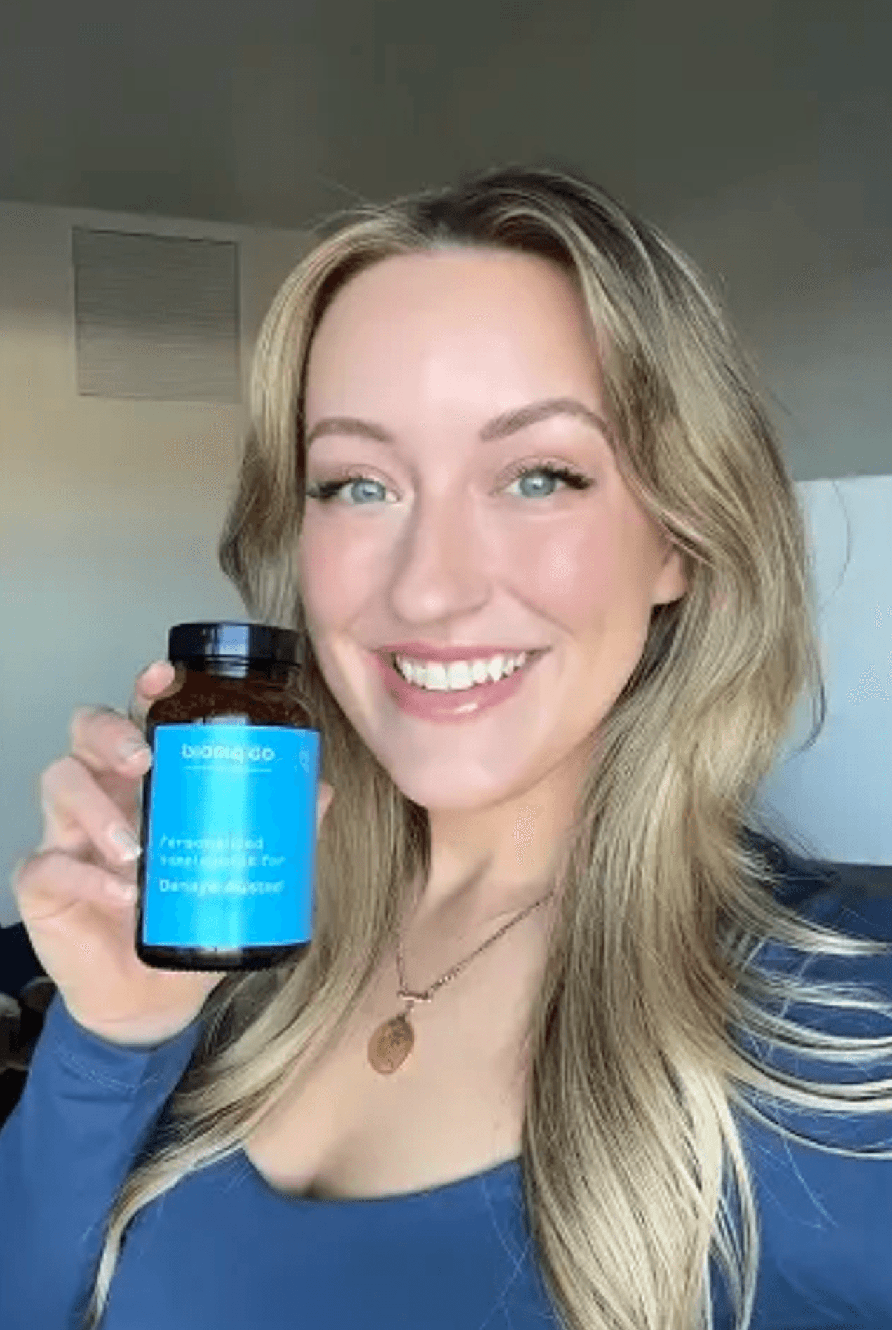 Mujer sonriendo sosteniendo una botella de Bioniq